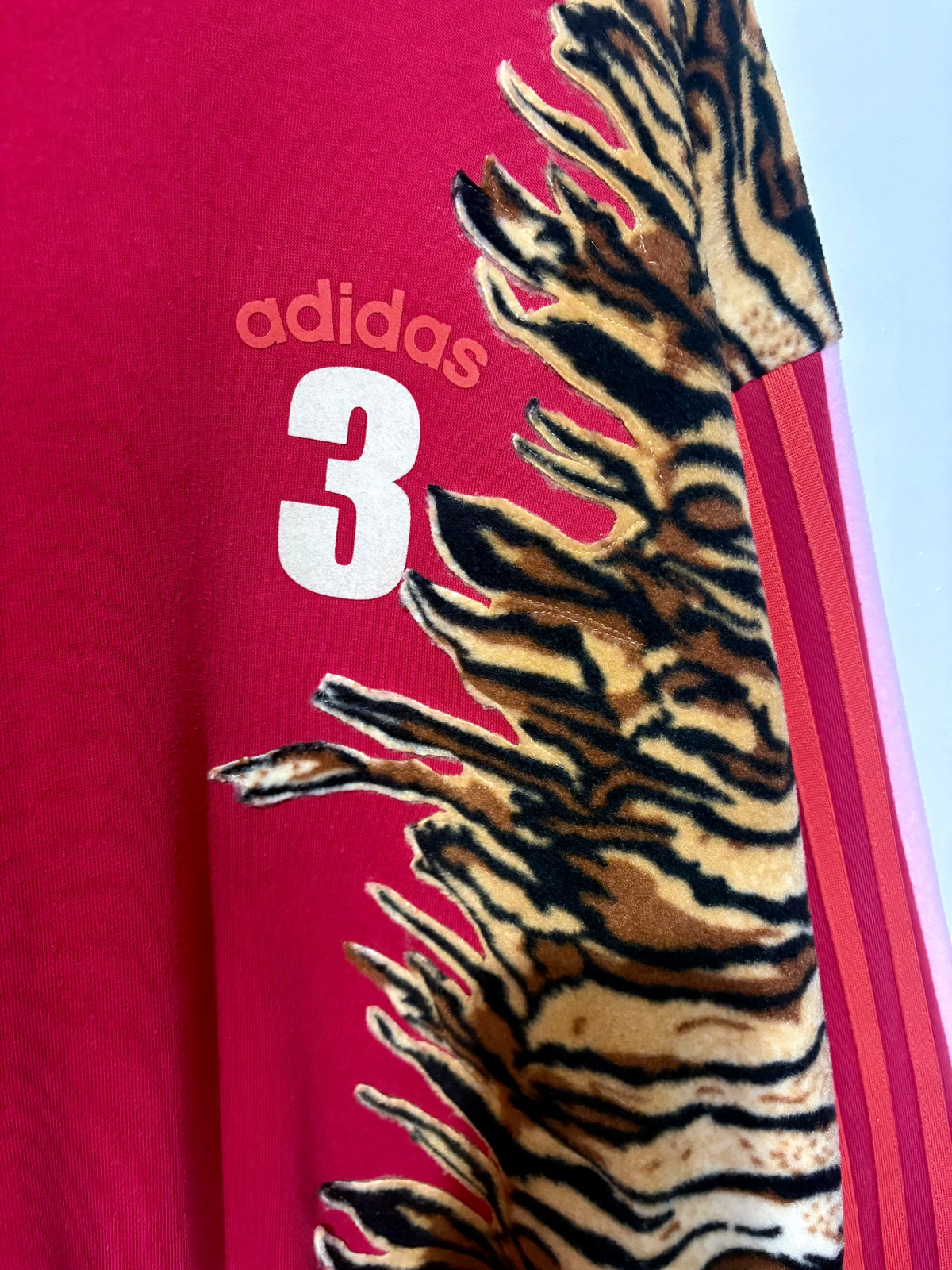Y2K red adidas tiger print and pink fleece patchwork sweatshirt.