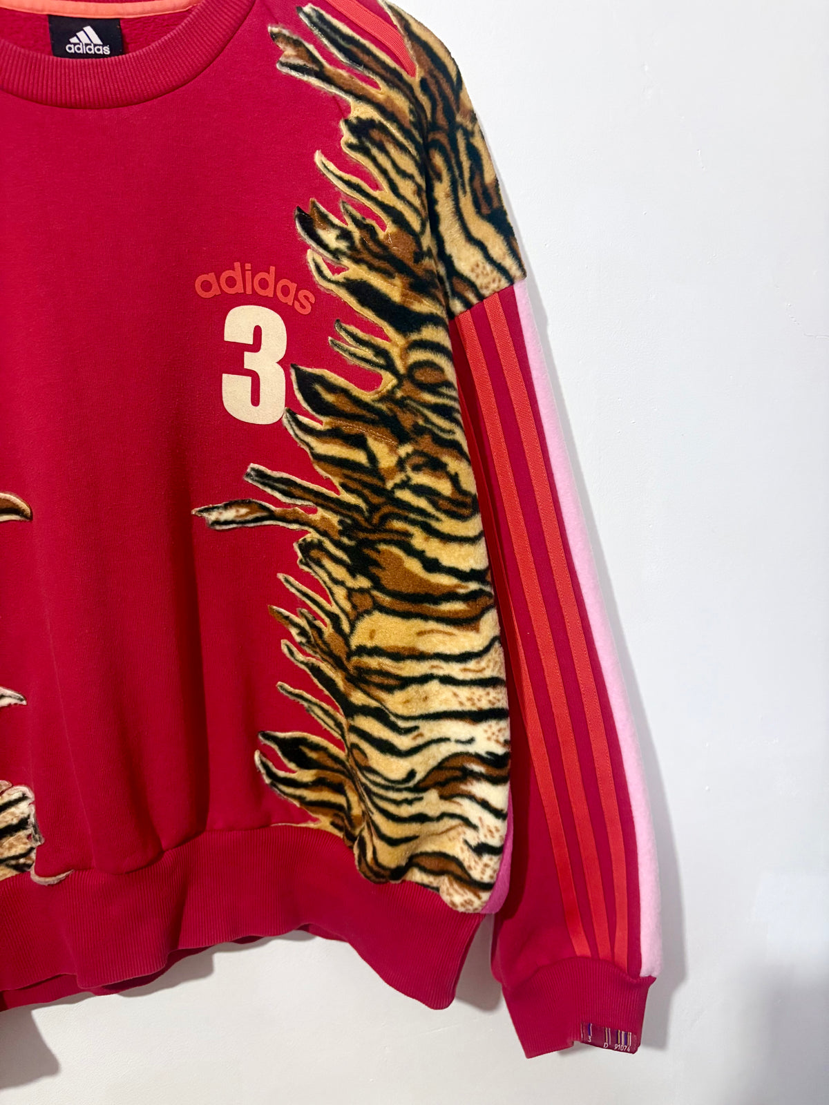 Y2K red adidas tiger print and pink fleece patchwork sweatshirt.